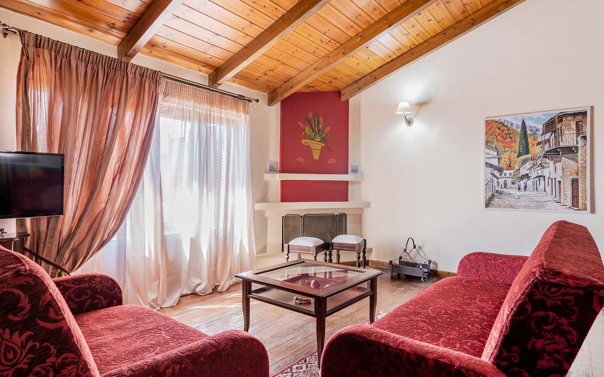 Room with sofas, a table, a fireplace and tv.